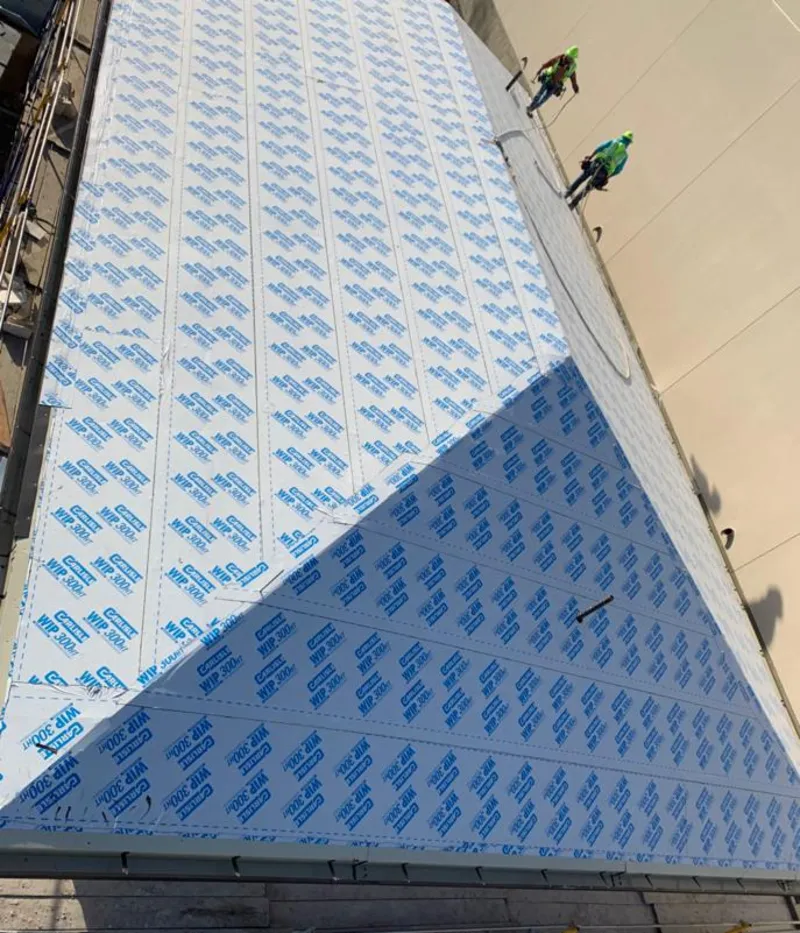 Professional roofers installing underlayment on a metal roof in Fanwood